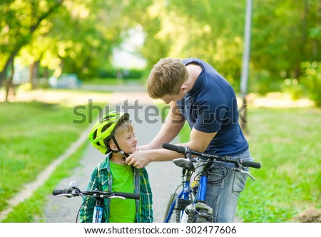 Father dresses his son bicycle helmet