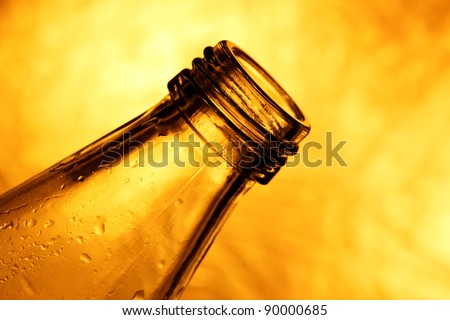 clear glass bottle silhouette on metallic bronze background