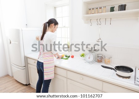 Asian woman cutting vegetables in the kitchen