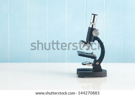 Microscope on the desk of blue background
