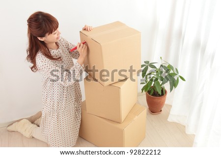 Write a young Asian woman in a cardboard box