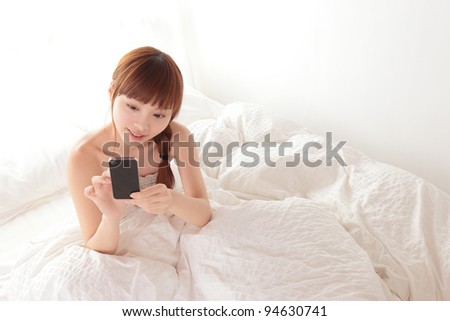 Women use a cell smart mobile phone on the bed