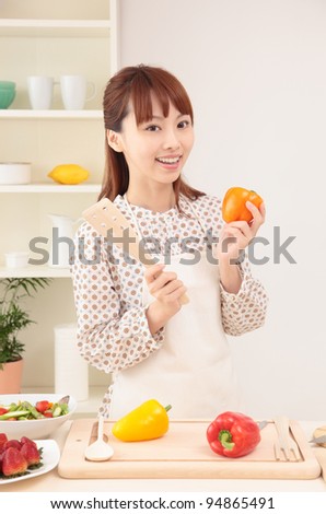 Asian beautiful woman with a smile is in preparation for cooking in the kitchen.