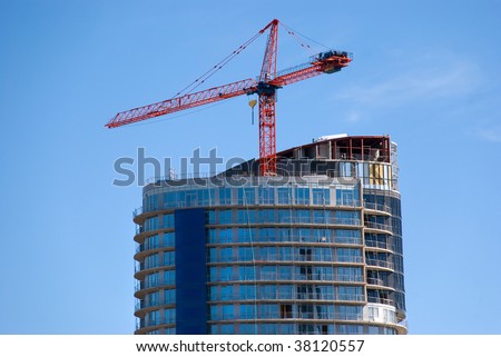 Oval shaped building and the red crane - a construction site.