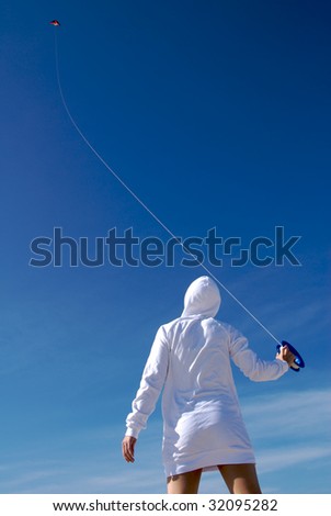 Young woman flying a kite.