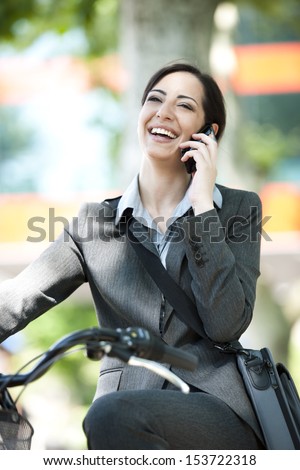 Businesswoman biking  and speaking on the phone