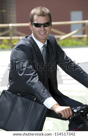 Young businessman riding a bike, eco/green concept