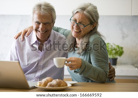 Senior couple at pc in the kitchen