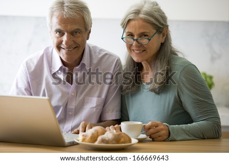 Senior couple at pc in the kitchen