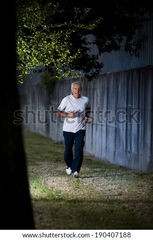 Active senior man running in the evening light