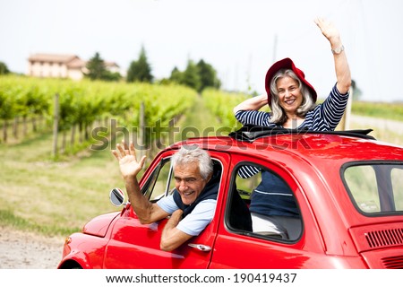 Senior happy couple driving vintage car