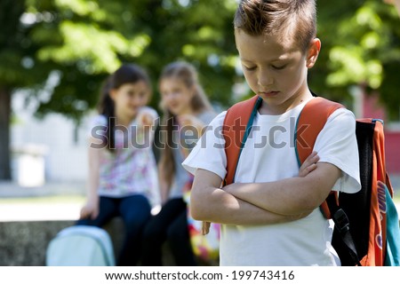 Two little girls pointing to the little sad boy focus on foreground Two little girls pointing to the little sad boy focus on foreground