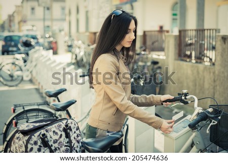 Young woman hiring a public bicycle