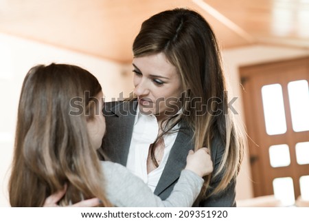 Mother embracing her little girl before leaving to work/or just back from work