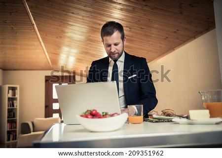 Businessman working at PC home during breakfast