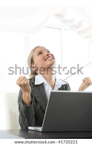 Attractive young business woman receiving good news while working on her laptop