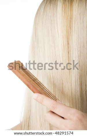 Beautiful blonde woman brushing her hair