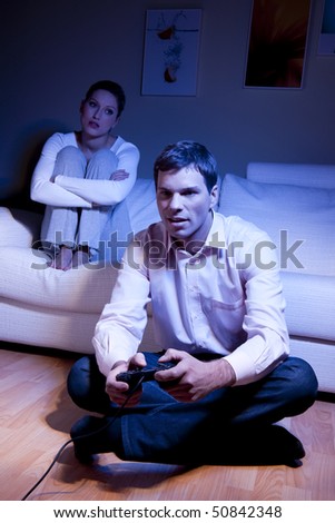 Man playing videogames, woman disappointed and bored