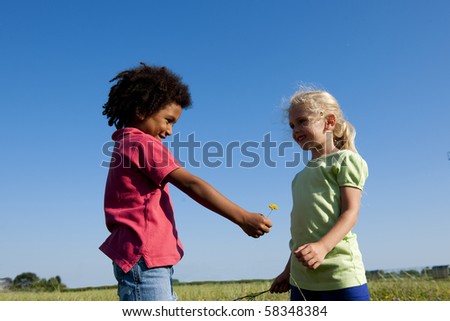 Little boy giving a flower to her friend