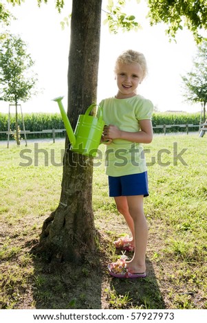 Little girl watering tree. Concept: taking care of nature