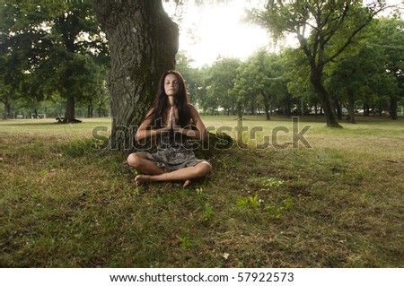 Young woman holding her hands against her chest and meditating in nature. Taken in Lipica, Slovenia. Concept: teenagers and nature, spiritual teenagers.