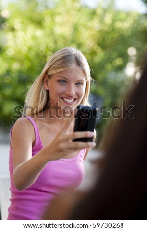 Beautiful teenage girls photographing with camera phone