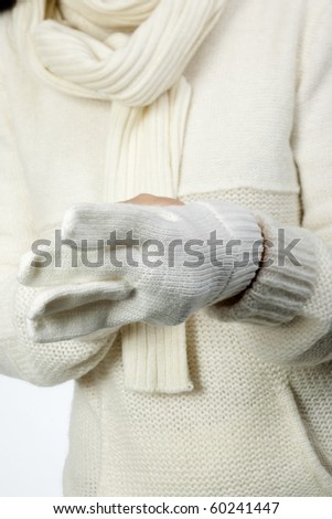 Young woman in soft white sweater, wearing mittens
