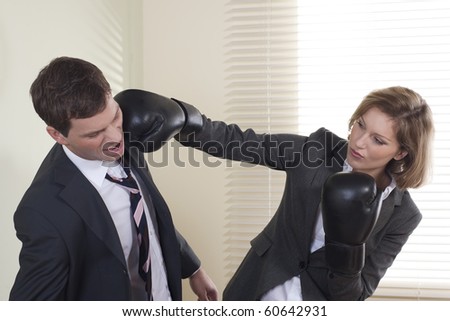 Businessman and woman boxing in the office
