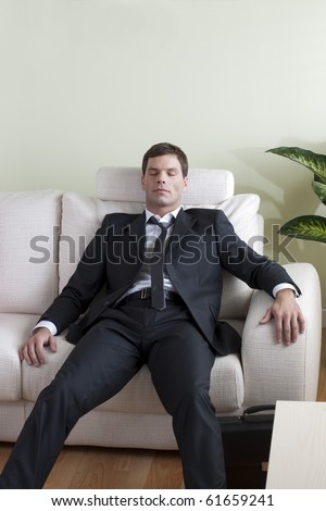 Tired business man on sofa