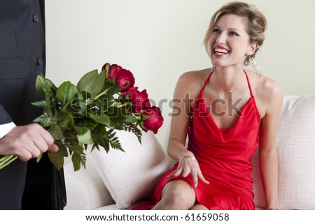 Happy beautiful woman receiving red roses on Valentine\'s Day, Birthday or Wedding Anniversary