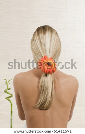 Back of woman with flower in her blond hair