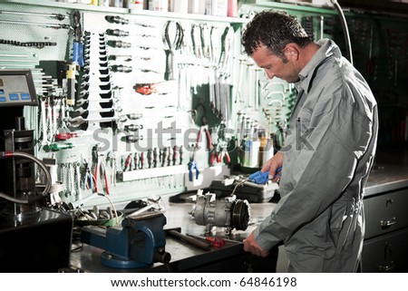 Close-up of a smiling mechanic inside his auto repair shop