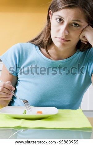 Sad woman in front of her small diet meal