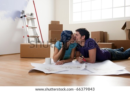 Young couple on the floor, making projects about their new home