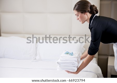 Maid making bed in hotel room Maid making bed in hotel room