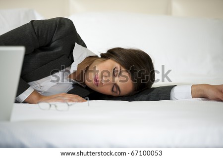Businesswoman asleep on the bed, hotel or domestic room