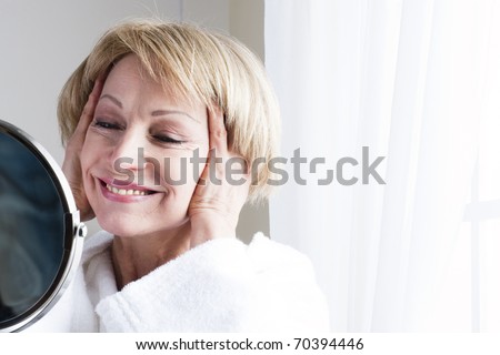 Mature woman looking at herself in the mirror