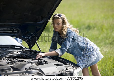 Worried young woman with her broken car, calling for assistance