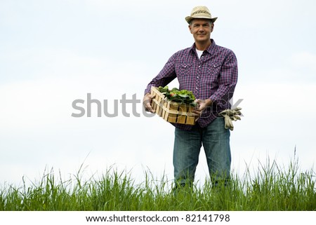 Farmer carrying  a crate of vegetables
