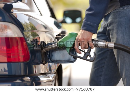 Service station worker filling up car with fuel, close-up