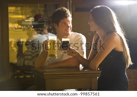 Young couple on a date enjoying their drink in a pub/bar