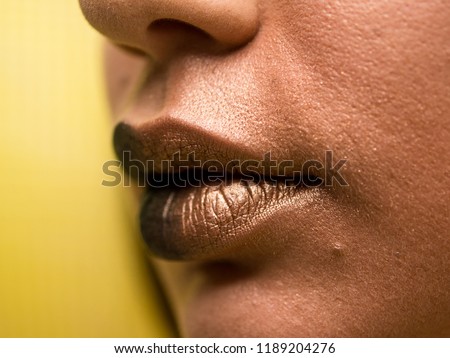 Lips make-up. Beauty high fashion trendy black with gold colour gradient lips makeup sample, sexy mouth closeup.