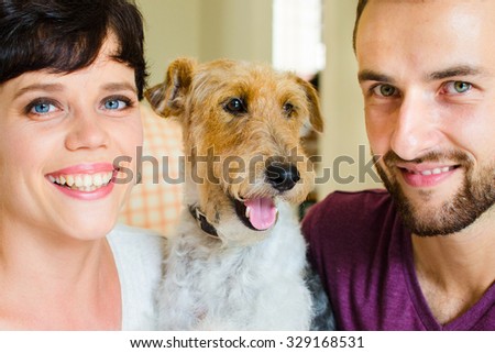 Man and woman in they house playing with the dog