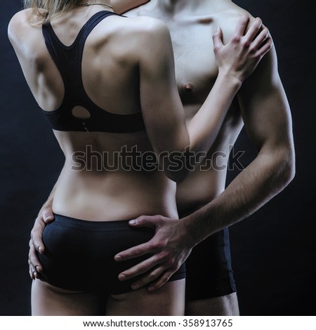 Couple in black lingerie. Seductive couple on the dark background.
