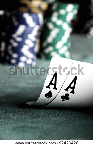 two aces on green table with blurry chips and background