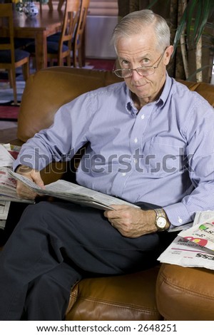 Senior man reading newspaper in upscale home.