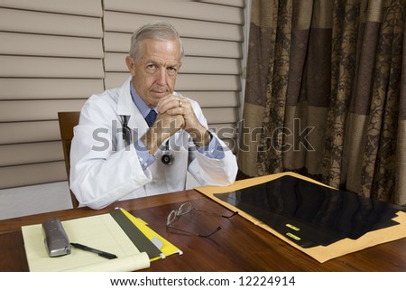Senior doctor at desk in medical setting.