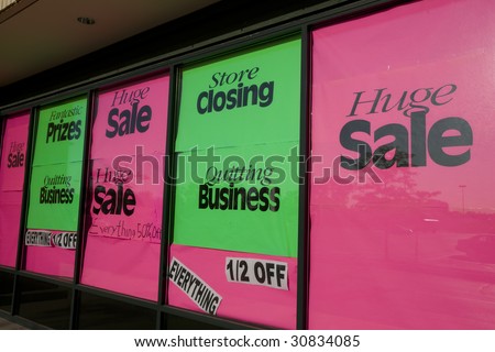 Bright store closing signs in a suburban shopping center.