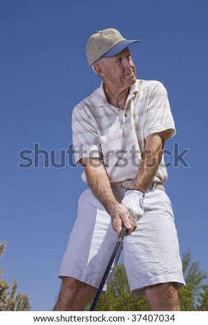 Senior golfer swinging the golf club on a summer day