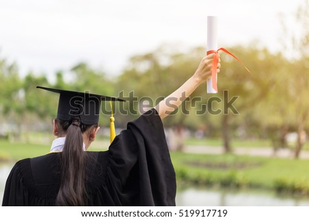 Graduate put her hands up and celebrating with certificate in her hand and feeling so happiness in Commencement day